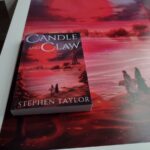 Candle and Claw book (paperback) on a cover poster.